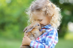 Une fille fait un câlin à son lapin.